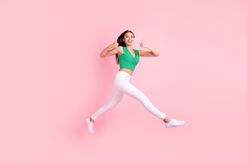 Fototapeta na wymiar Full length body size photo smiling jumping up showing like sign isolated pastel pink color background
