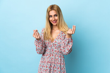 Young Uruguayan blonde woman over isolated blue background making money gesture