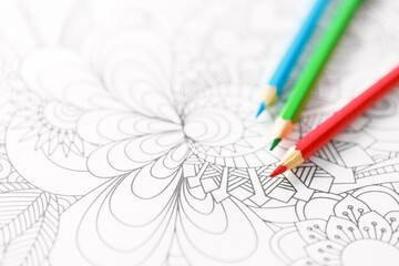 Adult coloring book and crayons on the table