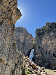 rock in the mountains with waterfall in background