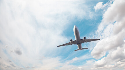 Fototapeta na wymiar White passenger airplane over the clouds - Travel by air transport