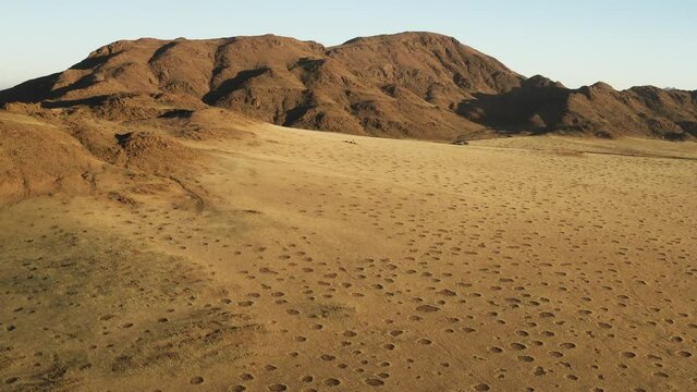 Spectacular epic aerial fly over view grassy vegetation famous fairy circles in the Namib desert 