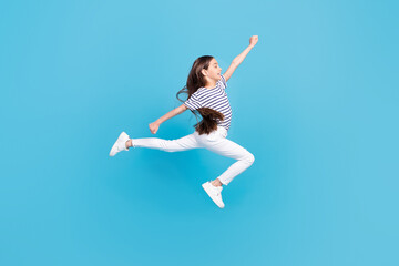 Fototapeta na wymiar Full body profile side photo of young girl jump up go walk run fast look empty space isolated over blue color background