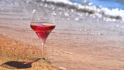 Wine glass with a cocktail by the sea.