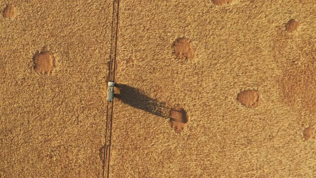 Spectacular epic high aerial view of a safari vehicle driving through the grassy vegetation famous fairy circles in the Namib desert 