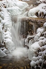 frozen waterfall in winter in forest