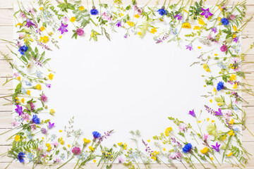 beautiful wild flowers on white sheet on wooden background