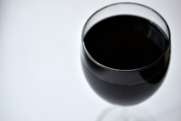 Large glass of red wine on a white background