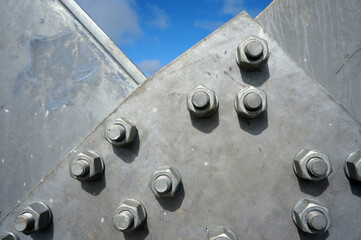 Bolts on a fragment of a massive girder bridge gray.   
