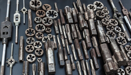 Taps, dies and wrenches for taps and dies on a black background. Manual tool for threading.