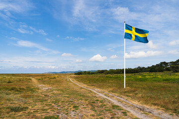 Swedish flag waving in wind with beautiful sky background. Swedish midsummer concept.