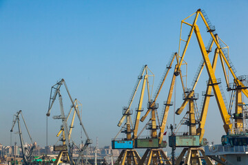 Port cranes on the territory of the seaport in Constanta Romania with blue sky. Territory of the seaport with cranes.