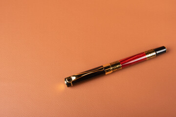 Fototapeta premium Fountain pen, beautiful details of a fountain pen exposed on a leather surface, selective focus.