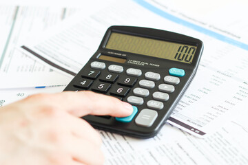A businessman at an office desk counts on a calculator. business and finance
