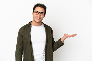 Caucasian handsome man over isolated white background holding copyspace imaginary on the palm to...