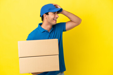 Delivery man over isolated yellow wall smiling a lot