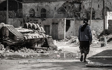 A young Yemeni man walks amid the destruction caused by the war in the city of Taiz, Yemen