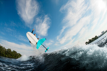 beautiful view of foilboard on which man effectively jumping on the wave - Powered by Adobe