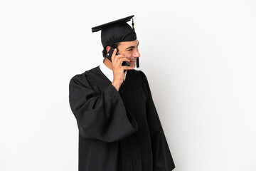 Young university graduate over isolated white background keeping a conversation with the mobile phone with someone