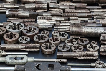 Taps, dies and wrenches for taps and dies on a black background. Manual tool for threading.