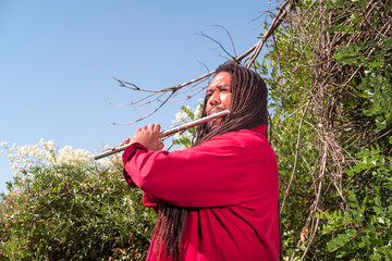 African-American flutist in the woods playing a flute solo © ralamst