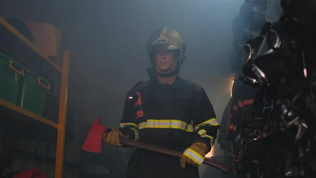 Fireman or firefighter with protective suit hold axe walk from inside room to the front then look around. Concept of staff for rescue people from fire.