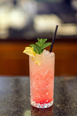 Cocktail in a glass with a straw. Orange and pink cocktail.