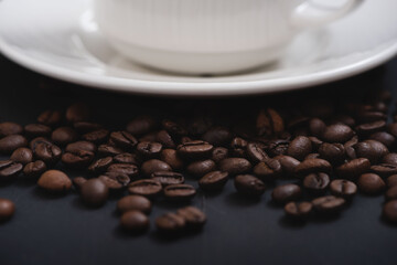 Some beans of coffee with a cup on background