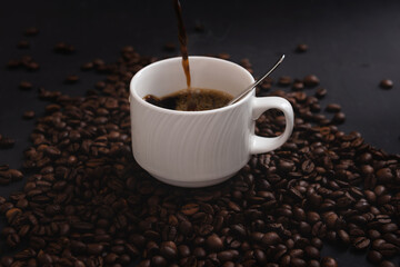 Pouring down some coffee on a cup isolated on coffee