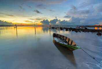Beautiful view with fishing boat at sunrise on Ocarina beach, batam pulau island