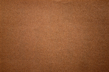 Sandpaper texture background where you can see the red-brown sand grain pattern on the sandpaper, suitable as a background for inserting text. Copy Space for designers to use on sandpaper.