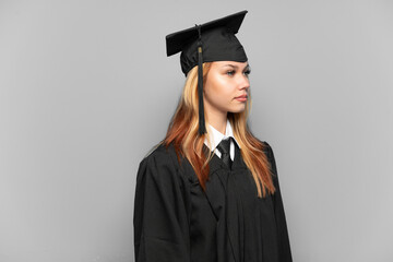 Young university graduate girl over isolated background looking to the side