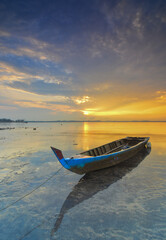 Beautiful view with fishing boat at sunrise on Ocarina beach, batam pulau island