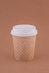 Beige disposable paper cup for coffee or tea.