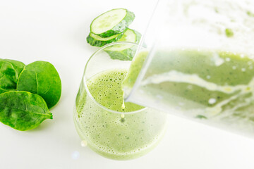 Smoothie recipe. Pouring green smoothie: spinach, apple, blender cucumber into glass. Home cooking. Vegan healthy detox eating, dietary and weght loss drink