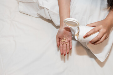 Many pills or dietary supplements are in the hands of a woman because the supplements will make her...