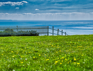 white fence and sky and ocean in background