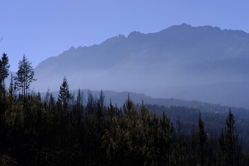 montañas andinas, y el humo de un incendio flotando