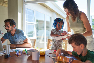Family working and playing at dining table