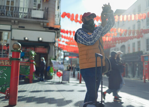 Male tourist using digital camera on sunny city street, London, UK