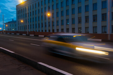 Fototapeta na wymiar Motion of a blurred car along the overpass in the evening.
