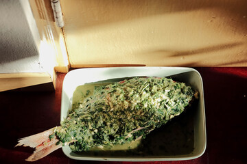 Fresh red snapper seasoned with fresh herb paste in kitchen