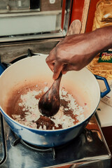 Diced onions being sauteed in a pan on stove