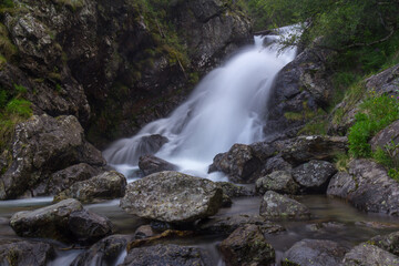 Fototapeta premium beautiful mountain waterfall with big stones and lots of water