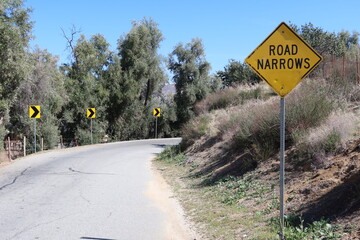Road Narrows Sign on a Curved Road