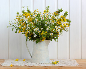 bouquet of white and yellow flowers in a jug