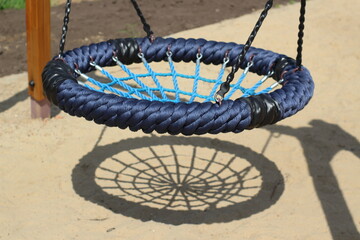 children's swings and their shadow, like a spider's web