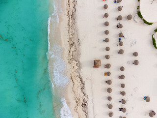 Ocean. Turquoise water. Calm. White sand. Beach. Beach umbrellas along the shore. View from above. Shooting from a drone. There are no people in the photo. Wallpaper. Texture. Background.