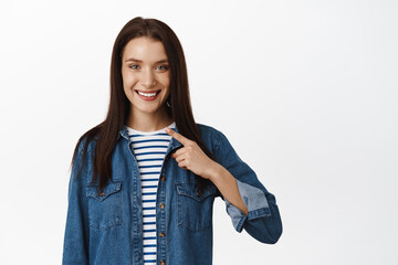 It is me. Smiling young woman, pointing at herself, nominating, volunteering to do smth, brag or...