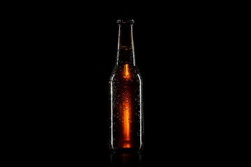 Small brown beer bottle with drops on black background
 - Powered by Adobe